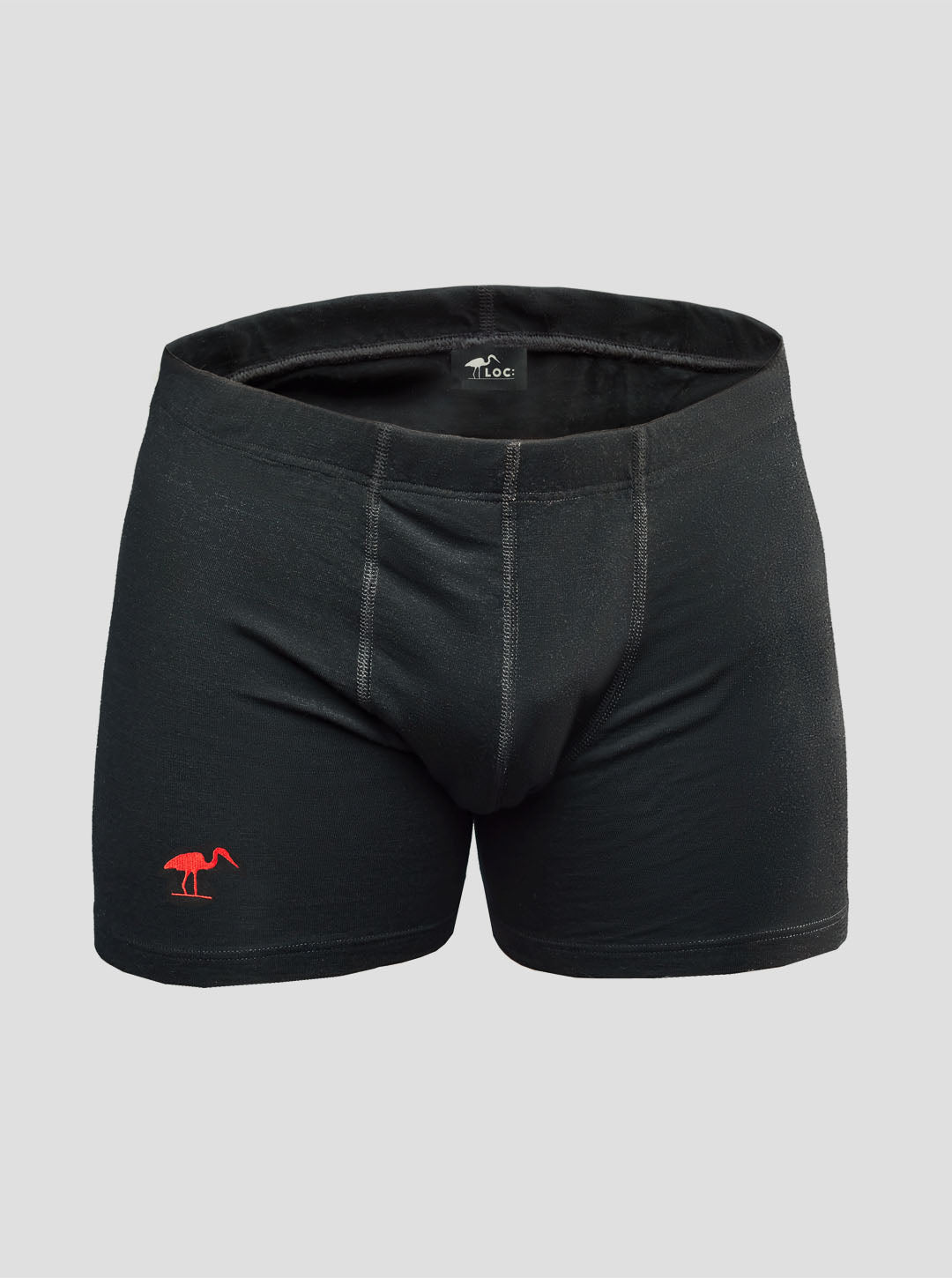 A pair of black merino wool boxer shorts with a small red LOC Heron logo on the left leg.