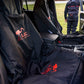 Black LOC 3-in-1 car seat covers with red LOC logos and text, shown installed on the front seats of a vehicle interior. A person is visible standing outside the open driver's side door on grass in the background. He´s dressed in LOC Waders.